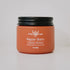 Orange jar of Pure Heritage Repair Balm with black lid on a light gray background